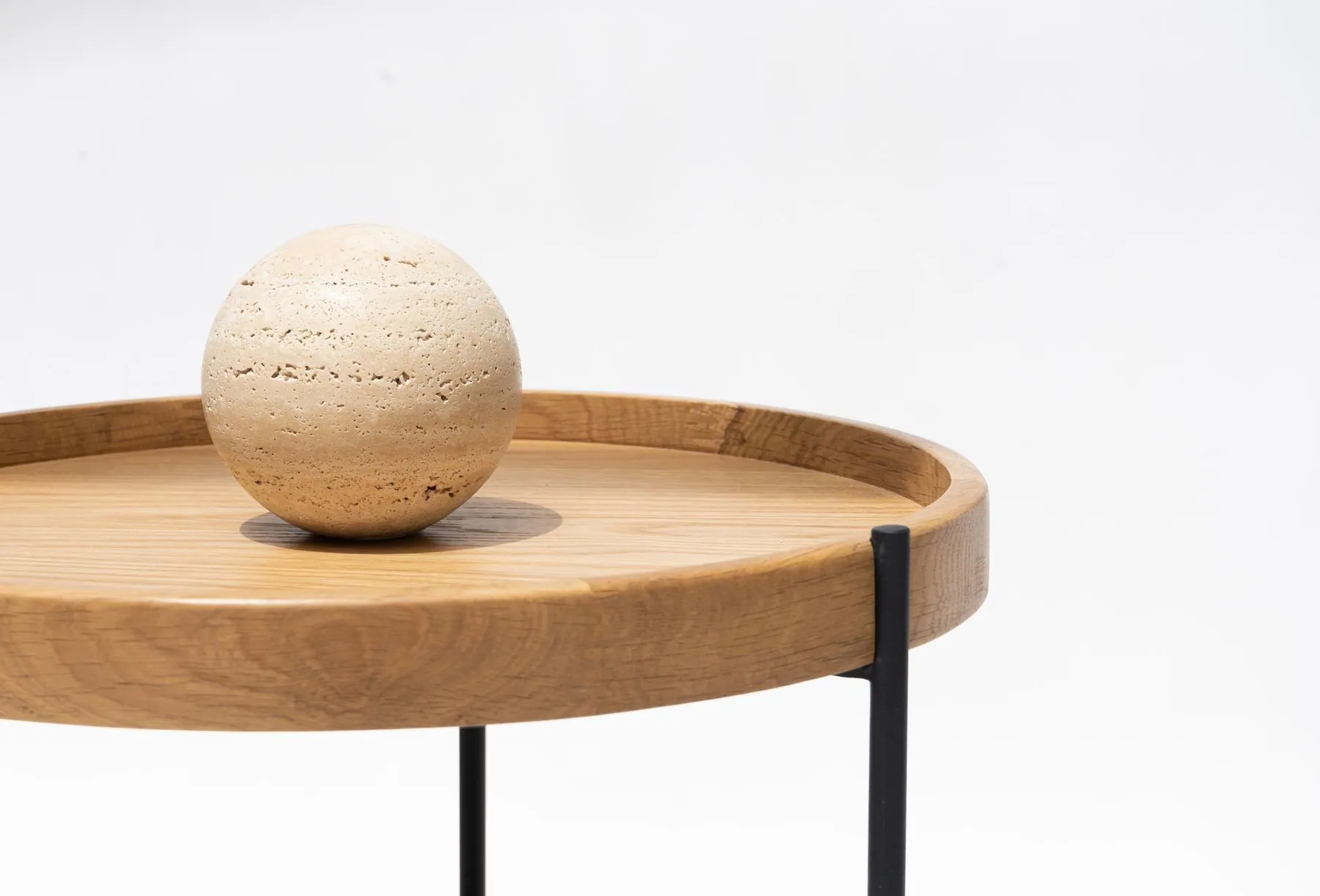 Round wooden tray table with a stone sphere on top