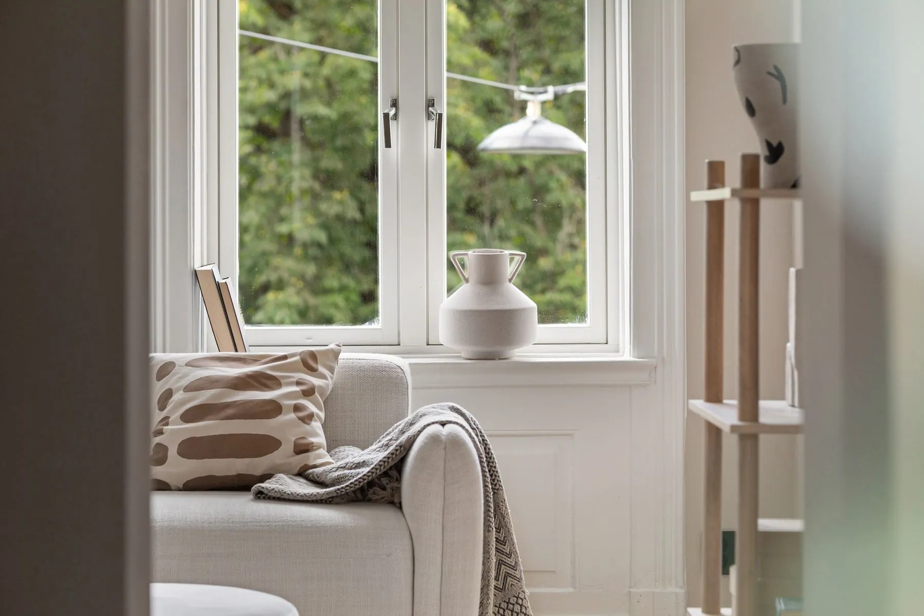 Sofa beside a bright window in a calm apartment living room