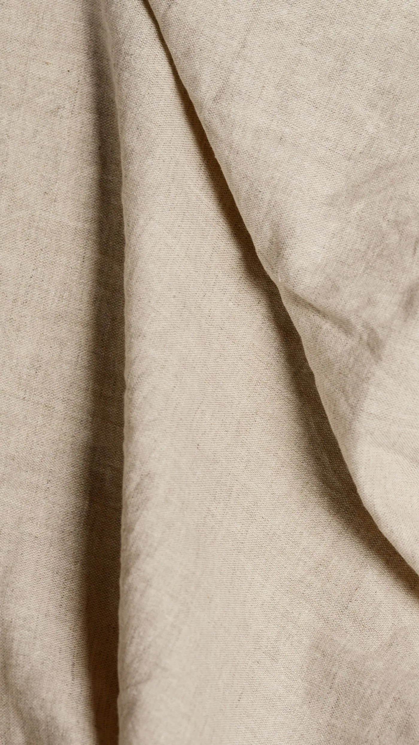 Close-up of soft beige linen fabric falling in folds